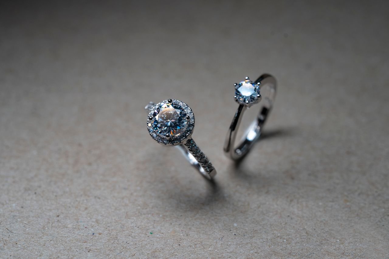 Fashion Rings Close-up image of luxury diamond engagement rings on a neutral background.