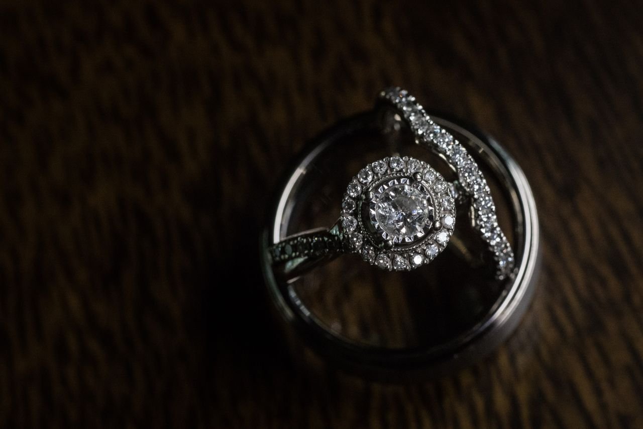 Fashion Rings Close-up of a diamond engagement ring set against a dark wooden background, showcasing luxury.