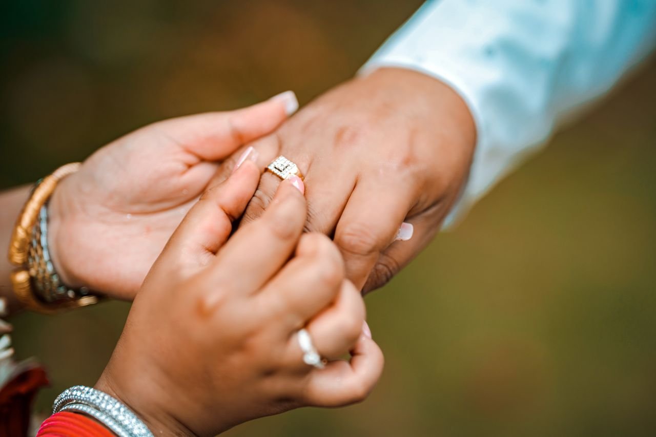 Promise Rings Close-up of a couple exchanging wedding rings, showcasing love and commitment.