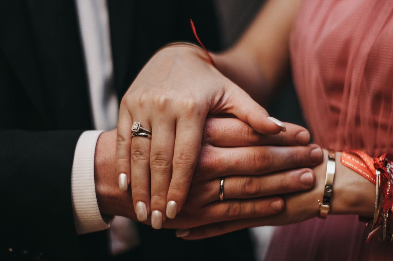 Stacking Rings Close-up of a couple's hands with engagement rings, symbolizing love and commitment.