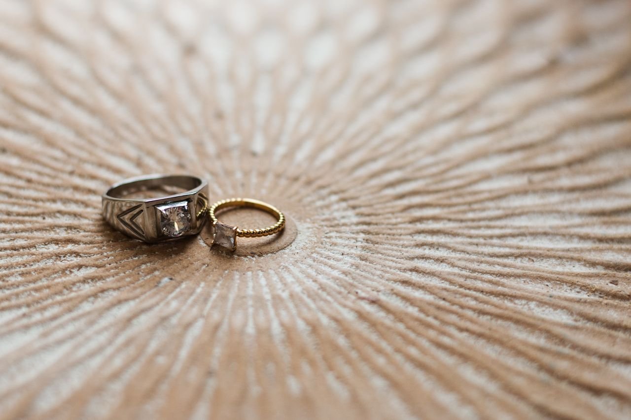 Stacking Rings Close-up of elegant silver and gold rings on a textured circular surface, showcasing luxury and craftsmanship.