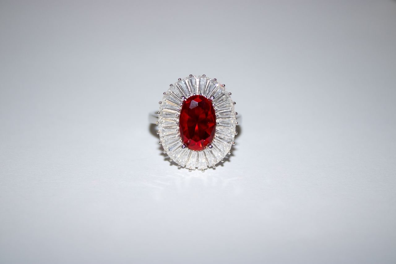 Cocktail Rings A stunning ruby and diamond silver ring elegantly displayed against a light background.