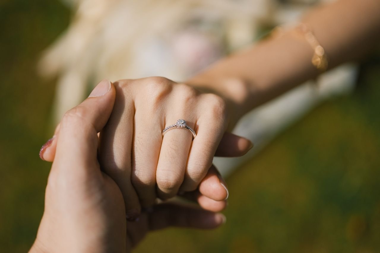 Promise Rings Close-up of hands with an engagement ring, symbolizing love and commitment.