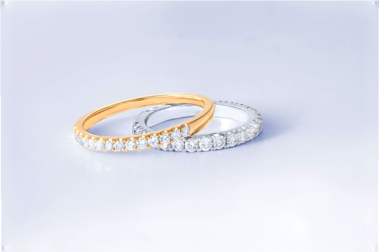 Stacking Rings Close-up of two exquisite diamond rings in gold and silver settings, showcasing luxury and craftsmanship.