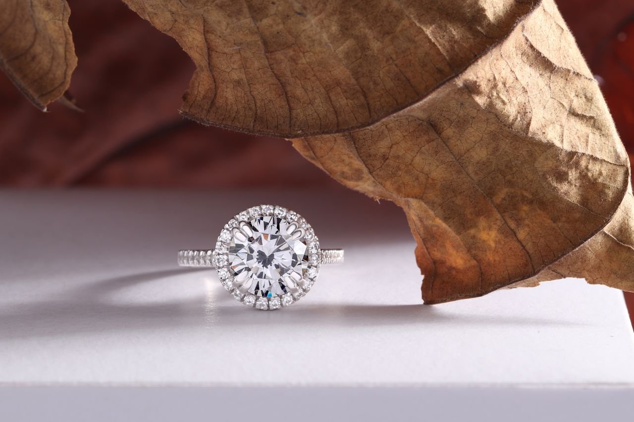Close-up of a dazzling diamond ring with a rustic leaf, perfect for showcasing elegance and natural beauty.