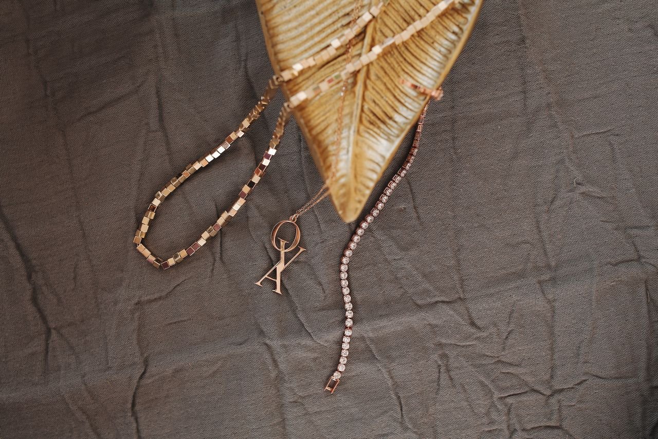 Personalized Jewelry Glamorous gold jewelry displayed on creased fabric, highlighting luxury design.