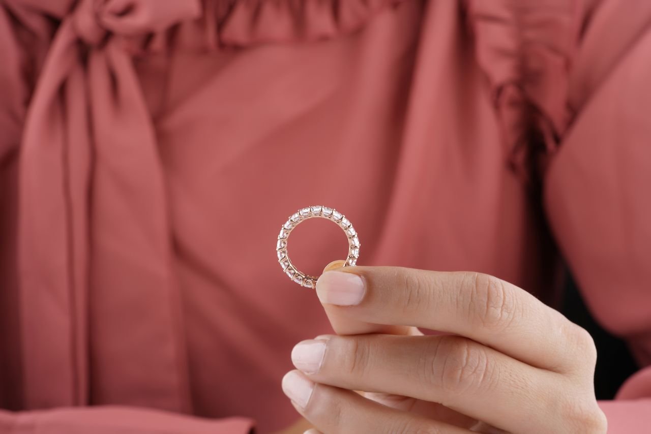 Stacking Rings Close-up of a woman's hand showcasing an elegant diamond eternity ring.